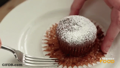 A Cupcake With Powdered Sugar On It Is On A White Plate With Everyday Food Written On It GIF
