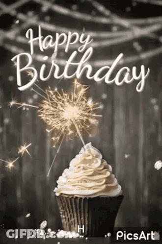 A Cupcake With Whipped Cream And A Sparkler On Top Of It . GIF