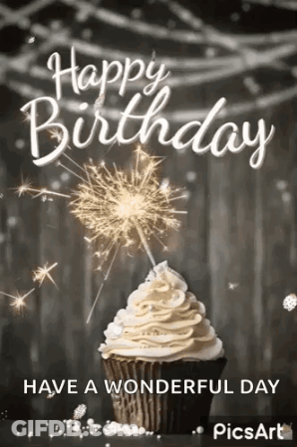 A Cupcake With Whipped Cream And A Sparkler On Top Of It . GIF