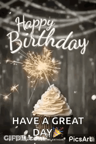 A Cupcake With Whipped Cream And A Sparkler On Top Of It . GIF