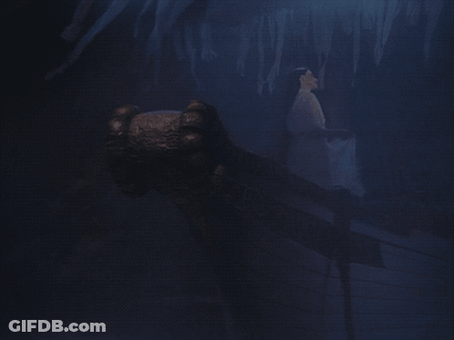 A Dark Cave With Ice Formations And A Hand Reaching Out GIF