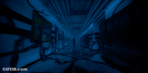 A Dark Hallway With A Sign On The Wall That Says " Emergency Exit " GIF