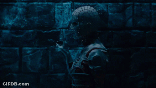 A Dark Room With A Brick Wall And A Statue Of A Skeleton GIF