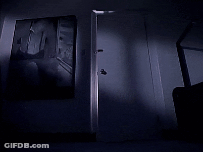 A Dark Room With A Door Knob And A Shadow On The Wall GIF