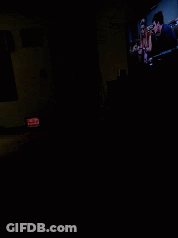 A Dark Room With A Red Sign That Says Exit On It GIF