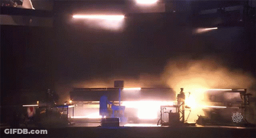 A Dark Room With Smoke Coming Out Of It And A Few Lights GIF