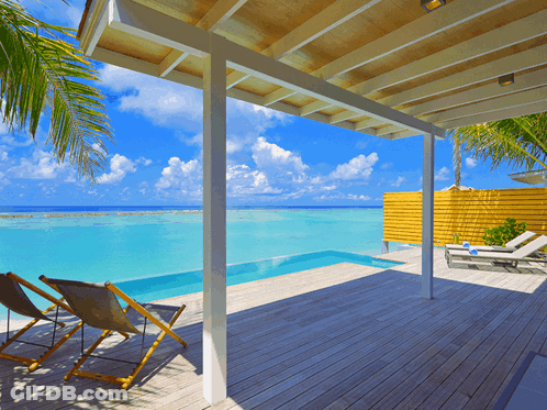 A Deck With Chairs And A Swimming Pool Looking Out To The Ocean GIF