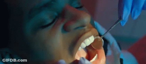 A Dentist Is Examining A Patient 'S Teeth With A Mirror . GIF