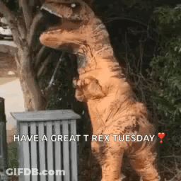 A Dinosaur In A T-Rex Costume Is Standing Next To A Trash Can And A Tree . GIF