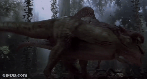 A Dinosaur Is Walking Through A Dark Forest With Trees In The Background GIF
