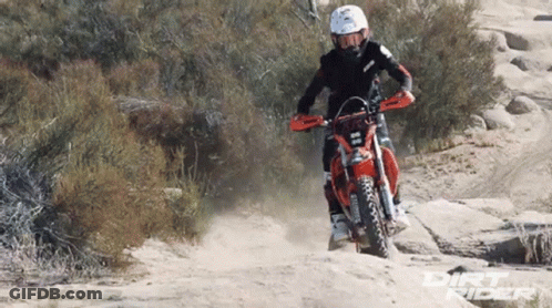 A Dirt Bike Rider Wearing A Helmet And Goggles Rides Through The Dirt GIF