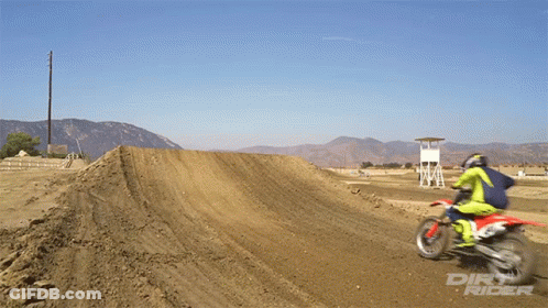 A Dirt Rider Is Riding A Dirt Bike On A Track GIF