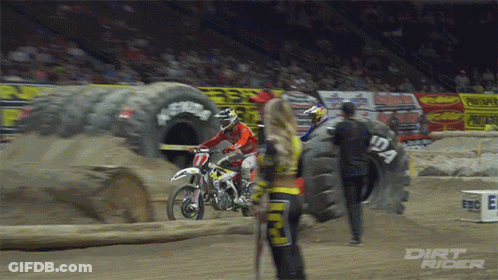 A Dirt Rider Is Standing Next To A Tire That Has The Number 12A On It GIF