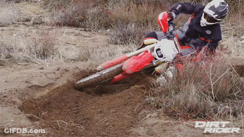 A Dirt Rider Riding A Red Dirt Bike In The Dirt GIF