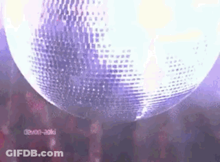 A Disco Ball Is Hanging From The Ceiling In Front Of A Crowd . GIF