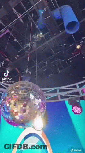A Disco Ball Is Hanging From The Ceiling Of A Room . GIF