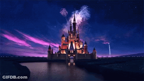 A Disney Castle Is Lit Up At Night With Fireworks GIF