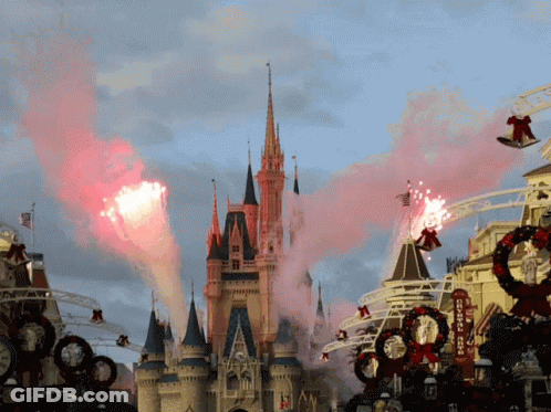 A Disney Castle With Smoke Coming Out Of It And A Sign That Says Disneyland GIF