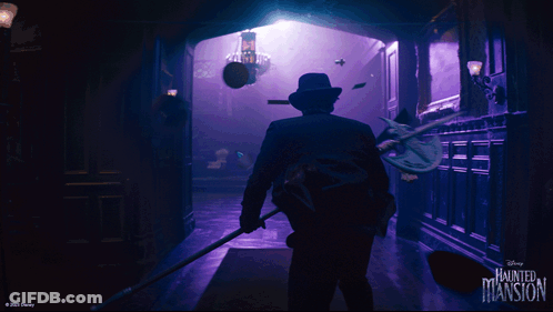A Disney Haunted Mansion Poster With A Man In A Suit GIF