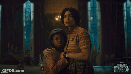 A Disney Haunted Mansion Poster With A Woman Hugging A Boy GIF