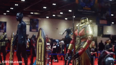 A Display Of Costumes At A Convention Has A Sign That Says 90 GIF
