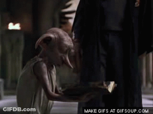 A Dobby From Harry Potter Is Kneeling Down Next To A Man In A Suit . GIF