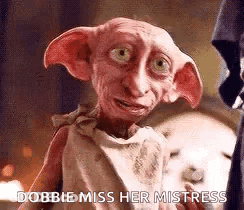 A Dobby From Harry Potter Is Standing In Front Of A Fireplace And Talking To Someone . GIF