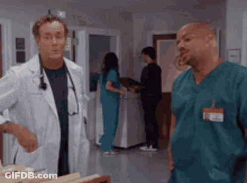 A Doctor And A Nurse Are Talking In A Hospital GIF