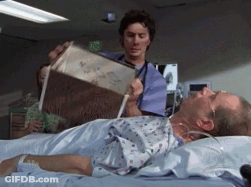 A Doctor Is Reading A Book To A Patient In A Hospital Bed . GIF