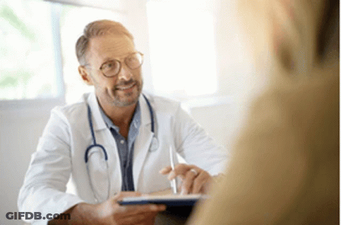 A Doctor Is Talking To A Patient In A Hospital Room While Holding A Tablet . GIF
