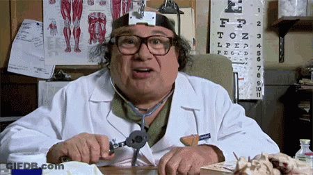 A Doctor Wearing Glasses And A Stethoscope Is Sitting At A Desk GIF
