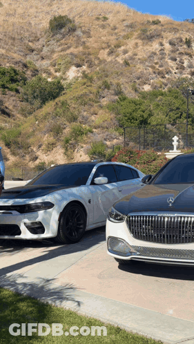 A Dodge Charger Is Parked Next To A Mercedes GIF