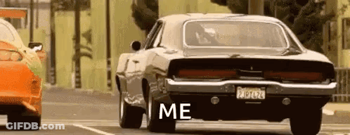 A Dodge Charger Is Parked Next To Another Car In A Parking Lot And Says `` Me '' . GIF