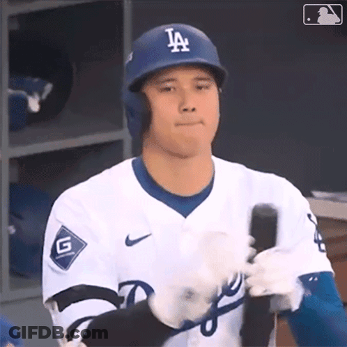 A Dodgers Baseball Player Is Holding A Bat In His Hand GIF