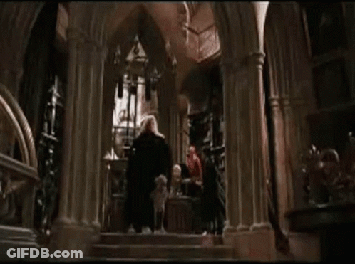 A Dog Is Laying On The Ground In Front Of A Man In A Cape . GIF