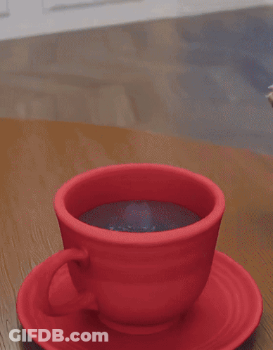 A Dog 'S Paw Rests On A Red Cup Of Coffee On A Saucer GIF