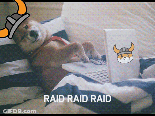 A Dog Wearing A Viking Helmet Is Laying On A Bed Using A Laptop GIF