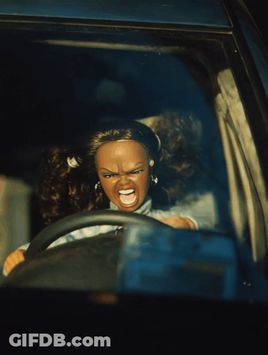 A Doll Is Driving A Car With An Angry Face GIF