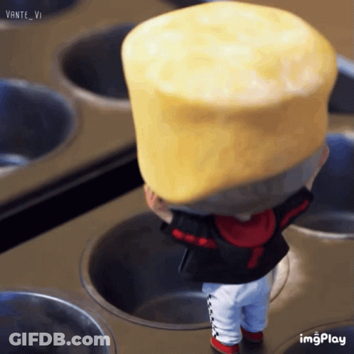 A Doll Is Holding A Large Yellow Cylinder On Its Head While Standing In A Muffin Tin GIF