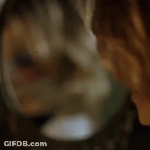 A Doll Is Looking At Herself In The Mirror GIF