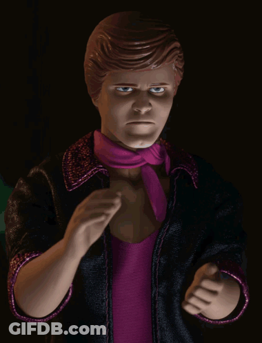 A Doll With A Purple Scarf Around His Neck And A Black Jacket GIF