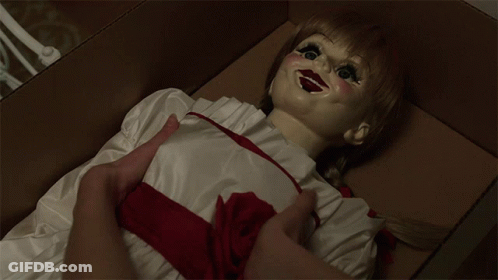 A Doll With A Red Ribbon Around Her Waist Is Laying In A Box GIF