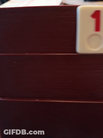 A Domino With The Number 2 On It Is On A Wooden Door GIF