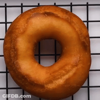 A Donut Is Sitting On A Wire Rack GIF