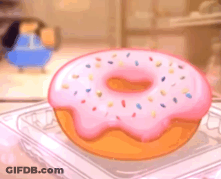 A Donut With Pink Frosting And Sprinkles Is In A Plastic Container On A Table . GIF