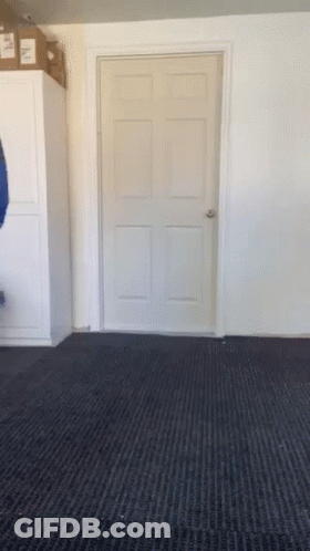 A Door In A Room With A Black Carpet And A Box On Top GIF