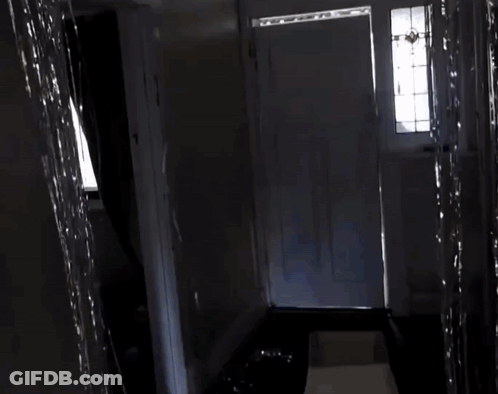 A Door Is Open To A Hallway With A Large Piece Of Paper In The Doorway GIF