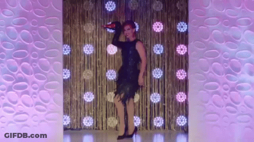 A Drag Queen Is Dancing On A Stage With A Microphone In Her Hand GIF