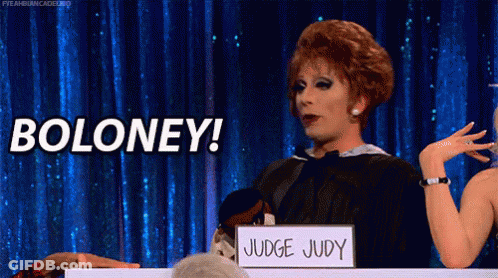 A Drag Queen Is Holding A Sign That Says Boloney GIF