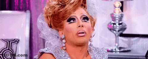 A Drag Queen Is Making A Funny Face In Front Of A Lamp . GIF